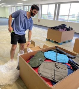 Altia intern opening boxes of backpacks